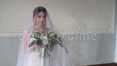 新娘穿着新娘礼服，带着花束和蕾丝面纱